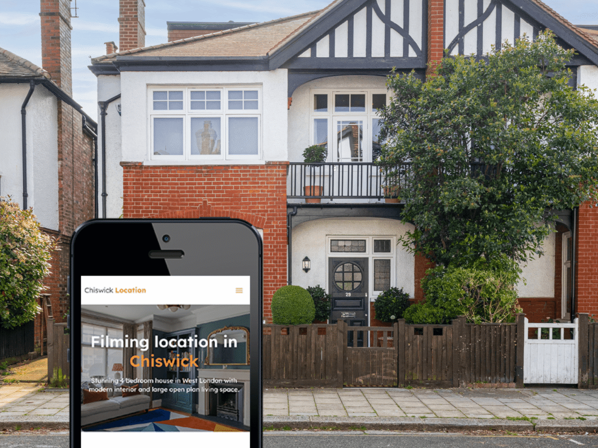New website Chiswick Location website on an iPhone, in front of the house